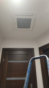 Montaż klimatyzatora kasetonowego w holu domu.